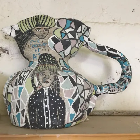 A ceramic jug decorated with a portrait and geometric patterns