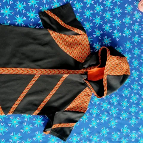 Panels of blue floral cloth and black and orange cloth stitched together