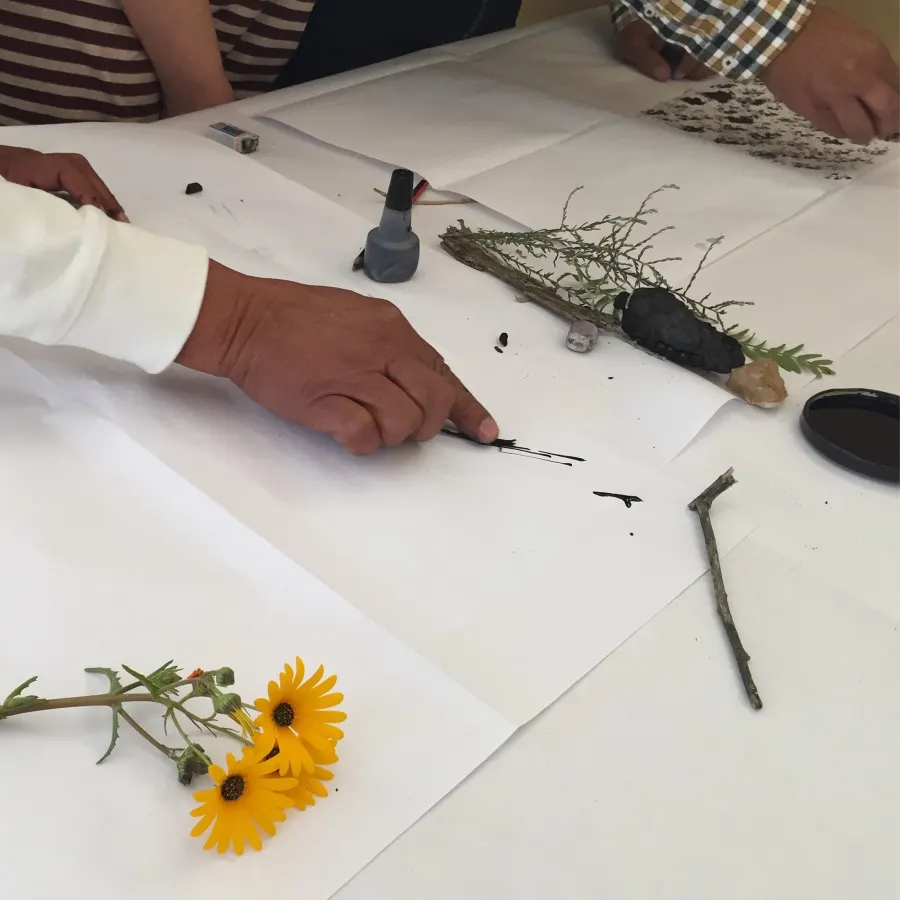 Teachers painting and drawing at a shared table during an Imbali workshop